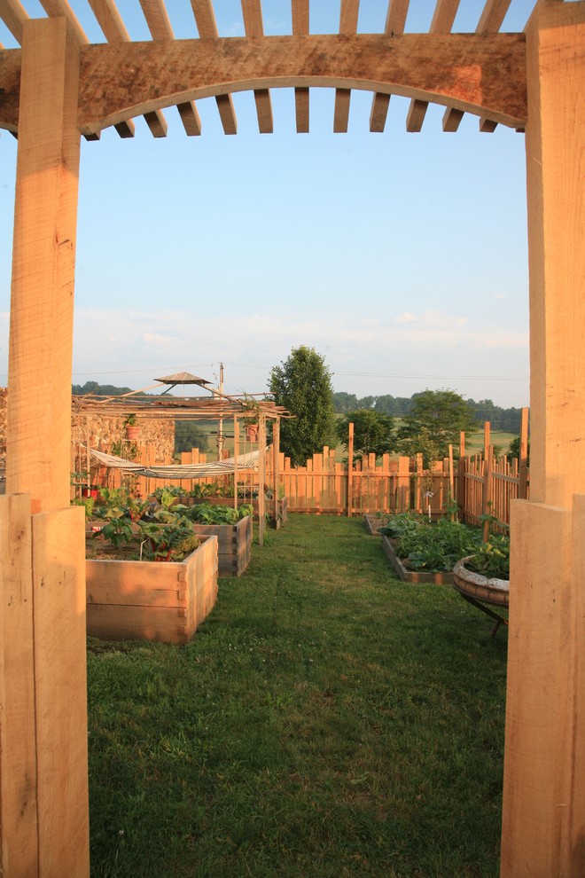 На фото: большой солнечный, весенний участок и сад на боковом дворе в стиле фьюжн с хорошей освещенностью