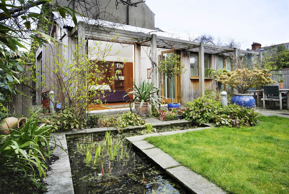 На фото: садовый фонтан на заднем дворе в современном стиле с