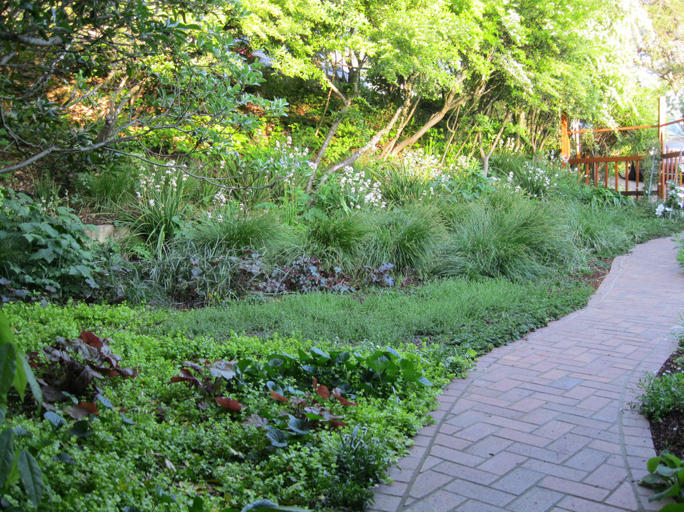 Idéer för rustika trädgårdar i skuggan framför huset på våren, med en trädgårdsgång och marksten i tegel