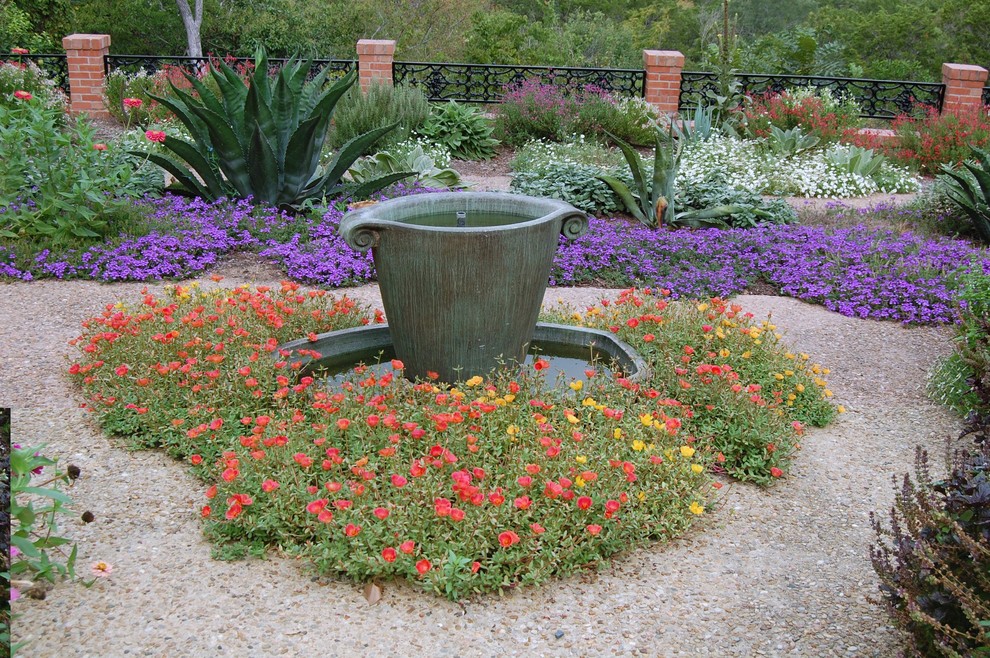 This is an example of a classic garden in Austin with a water feature.