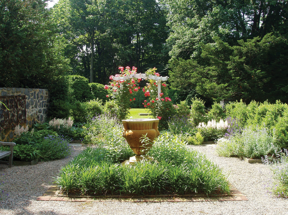 Ispirazione per un grande giardino formale chic esposto a mezz'ombra dietro casa con fontane e ghiaia