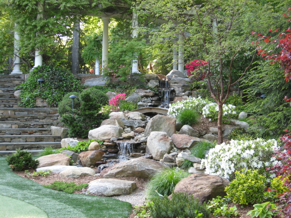 This is an example of a large traditional partial sun backyard stone waterfall in Miami for spring.