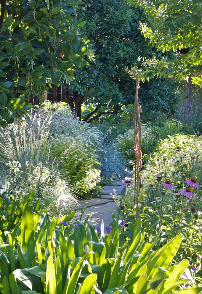 Modelo de camino de jardín tradicional de tamaño medio en primavera en patio trasero con jardín francés, exposición parcial al sol y adoquines de piedra natural