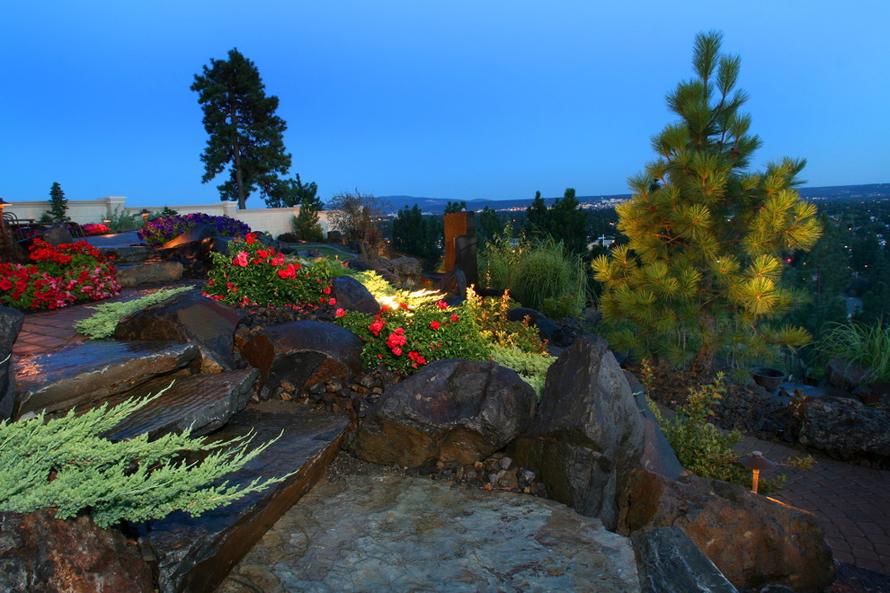 На фото: солнечный участок и сад на склоне в стиле фьюжн с хорошей освещенностью и покрытием из каменной брусчатки