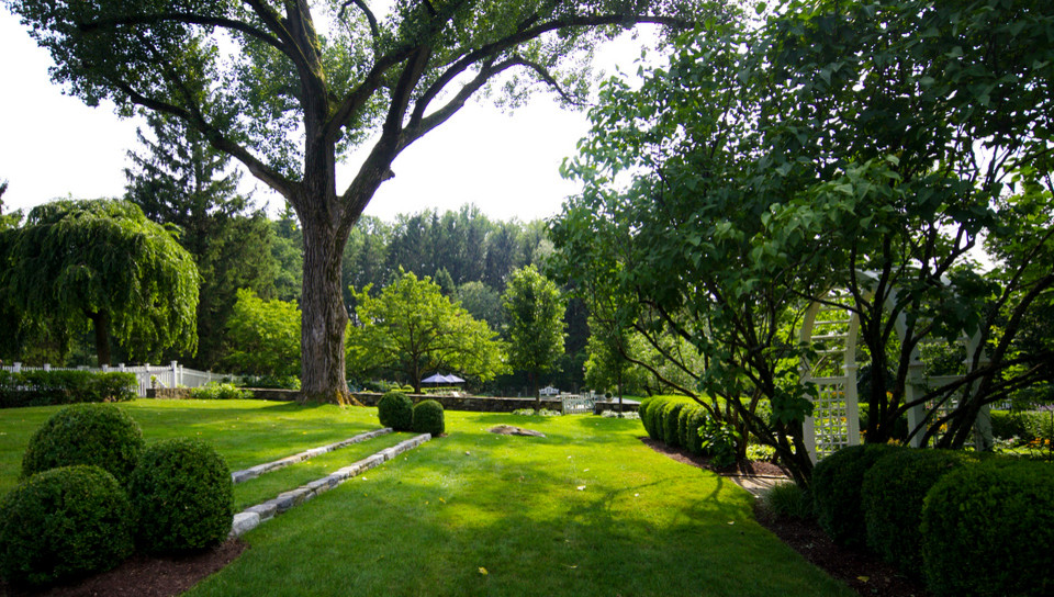 На фото: большой летний регулярный сад на заднем дворе в классическом стиле с полуденной тенью, садовой дорожкой или калиткой и покрытием из каменной брусчатки с