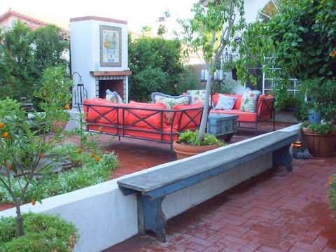 Пример оригинального дизайна: солнечный, весенний засухоустойчивый сад среднего размера на внутреннем дворе в средиземноморском стиле с уличным камином, хорошей освещенностью, мощением клинкерной брусчаткой и с каменным забором