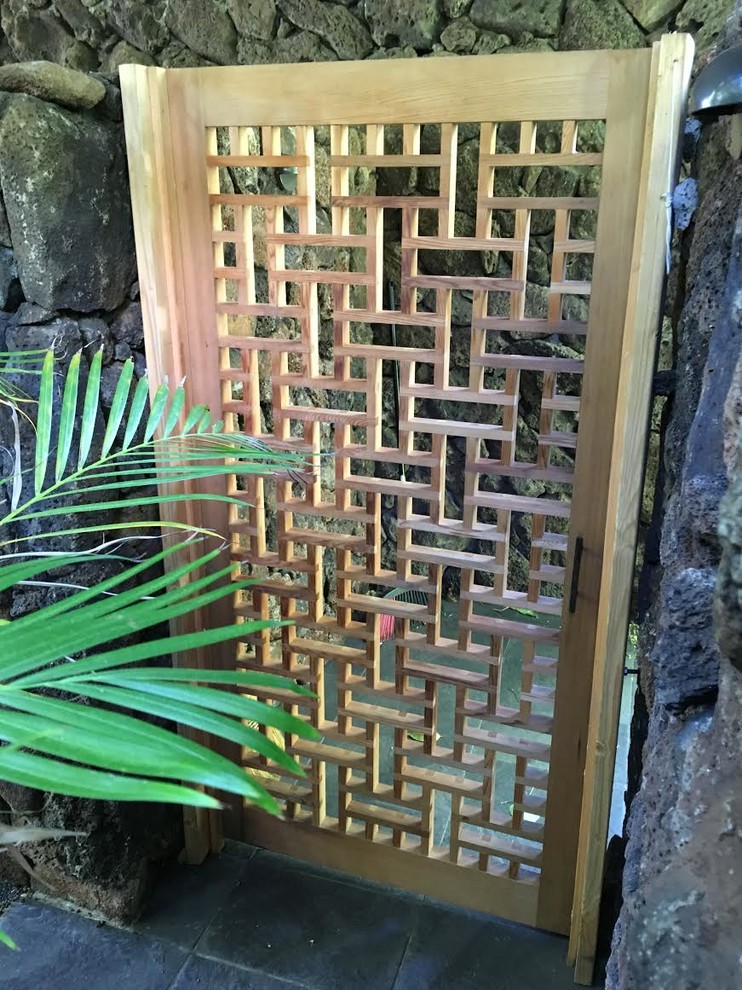 Immagine di un piccolo giardino tropicale esposto a mezz'ombra dietro casa con un ingresso o sentiero e pavimentazioni in pietra naturale