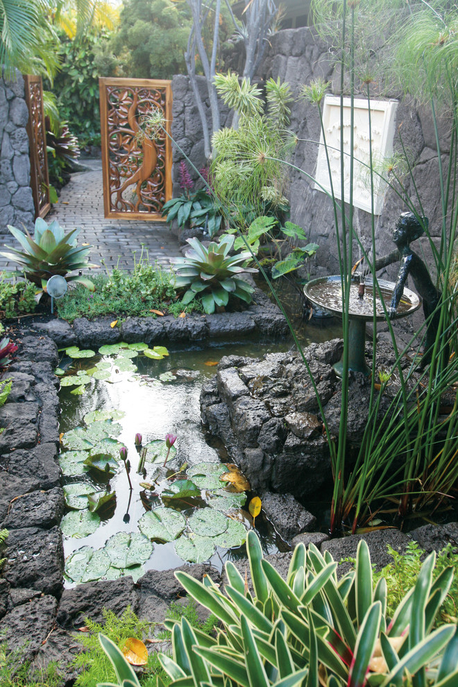 На фото: большой сад с прудом на заднем дворе в морском стиле с полуденной тенью и мощением тротуарной плиткой