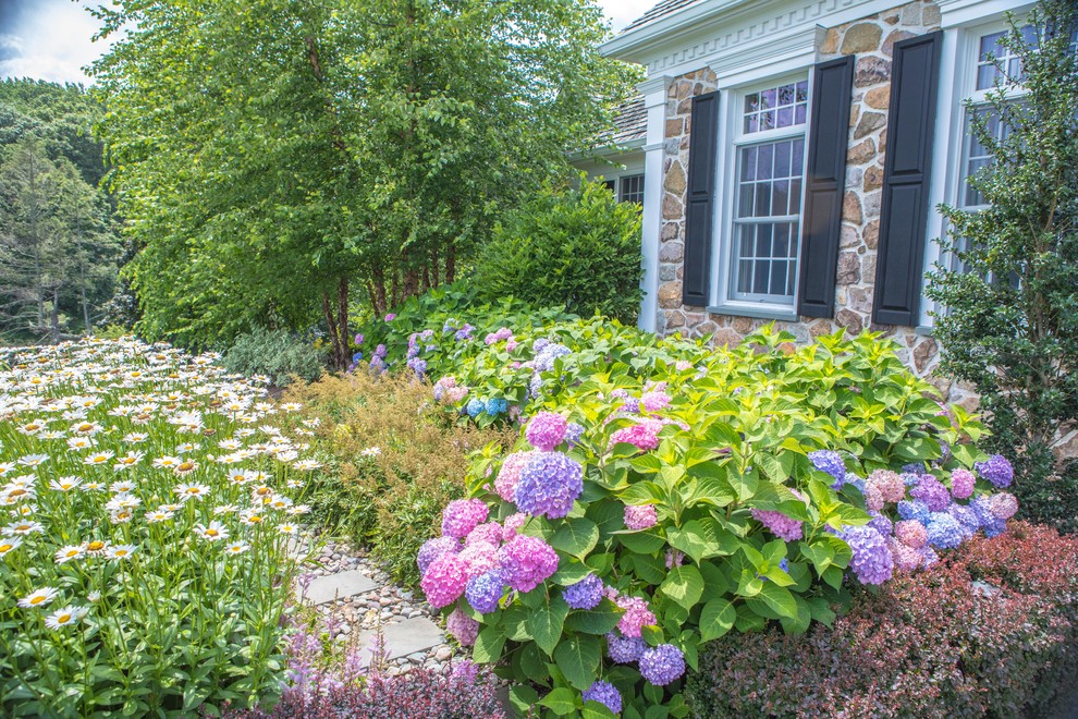 Imagen de camino de jardín clásico de tamaño medio en verano en patio trasero con jardín francés, exposición parcial al sol y adoquines de piedra natural