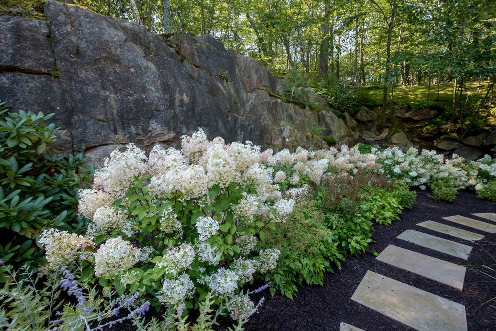 Design ideas for a mid-sized traditional partial sun backyard stone landscaping in New York for summer.