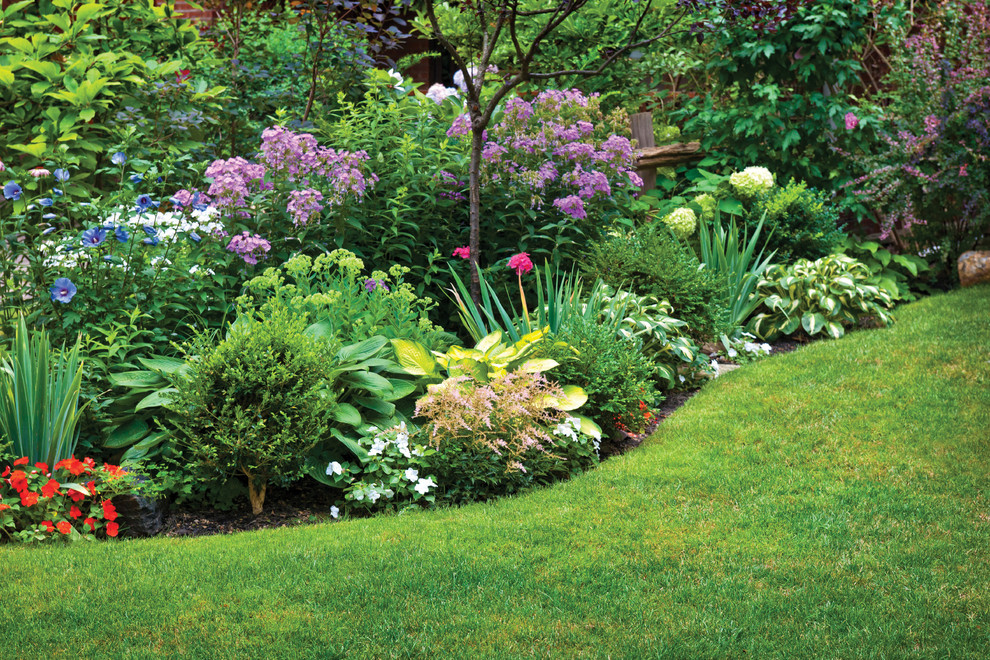 Diseño de jardín tradicional de tamaño medio en primavera en patio delantero con jardín francés, exposición parcial al sol, mantillo y parterre de flores