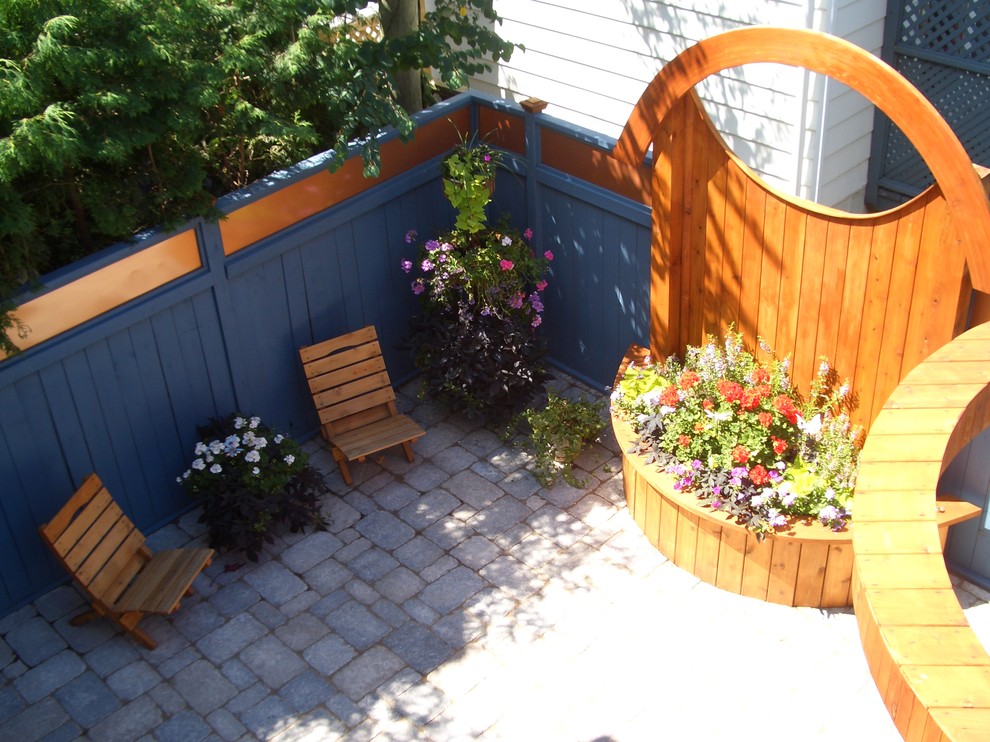 This is an example of a mid-sized asian partial sun backyard concrete paver landscaping in Ottawa for summer.