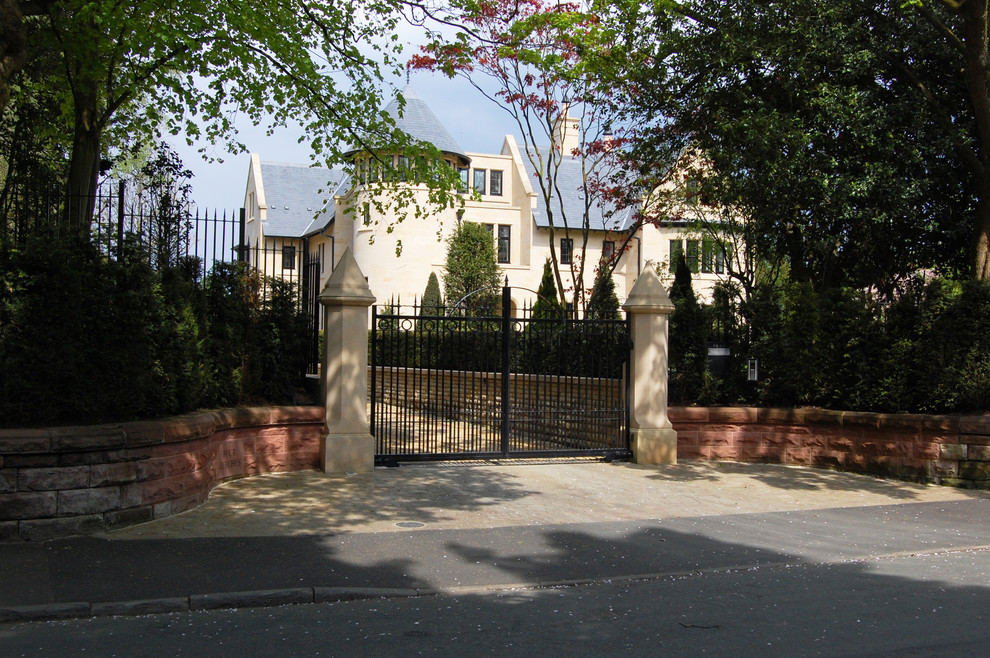 Пример оригинального дизайна: участок и сад на переднем дворе в классическом стиле с подъездной дорогой и покрытием из каменной брусчатки