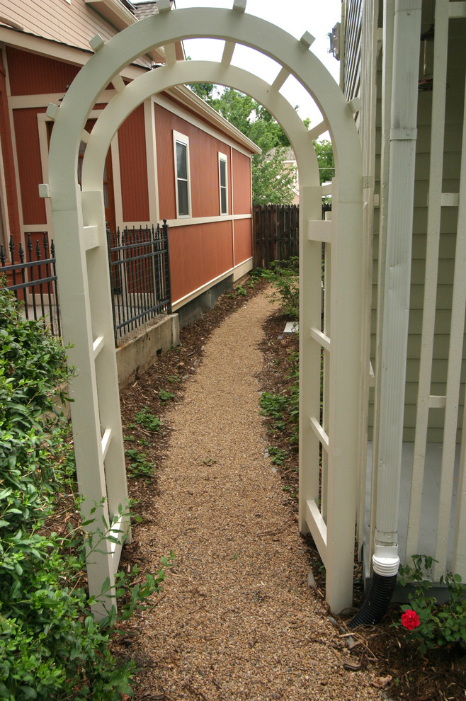 Immagine di un giardino vittoriano esposto a mezz'ombra di medie dimensioni e nel cortile laterale in estate con un ingresso o sentiero e ghiaia