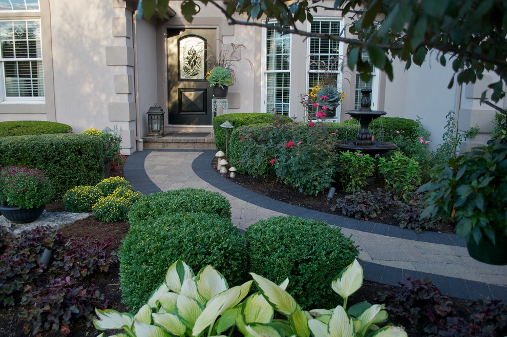 Пример оригинального дизайна: летний участок и сад среднего размера на переднем дворе в классическом стиле с подъездной дорогой и мощением клинкерной брусчаткой