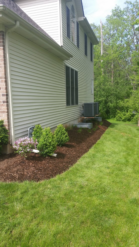This is an example of a mid-sized traditional side yard mulch formal garden in Chicago.