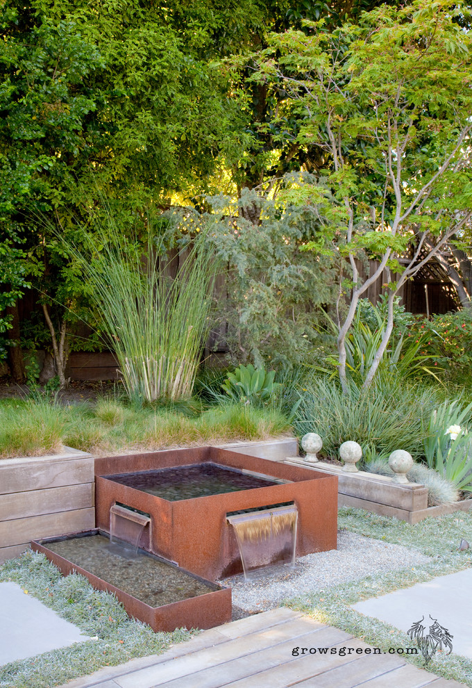 Imagen de jardín de secano nórdico de tamaño medio en patio trasero con brasero, exposición total al sol y adoquines de hormigón