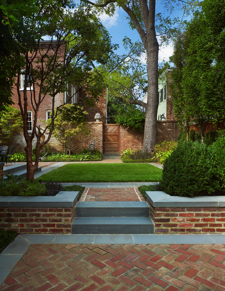 This is an example of a large contemporary partial sun backyard brick formal garden in DC Metro for spring.