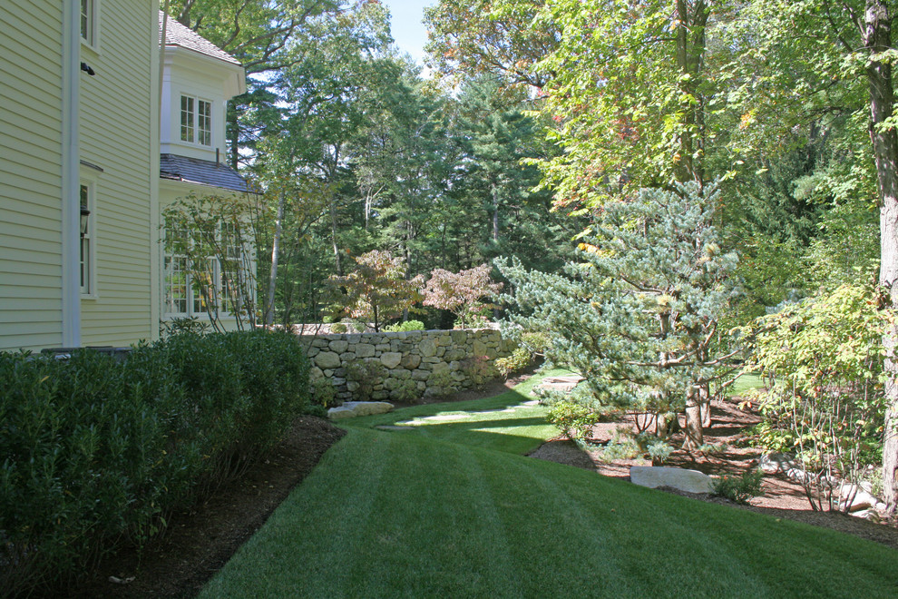 Foto de jardín tradicional grande en verano en patio lateral con muro de contención y exposición total al sol