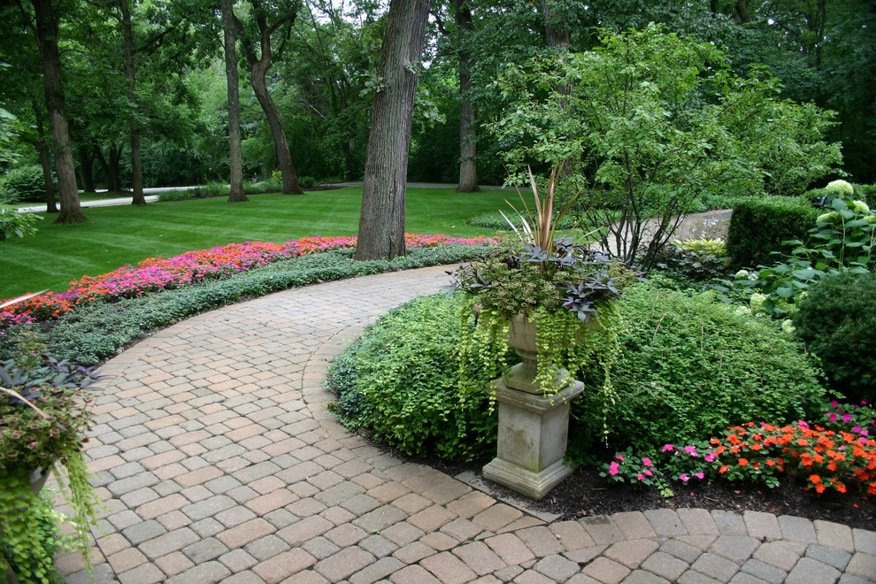 This is an example of a mid-sized traditional shade front yard concrete paver landscaping in Chicago for summer.