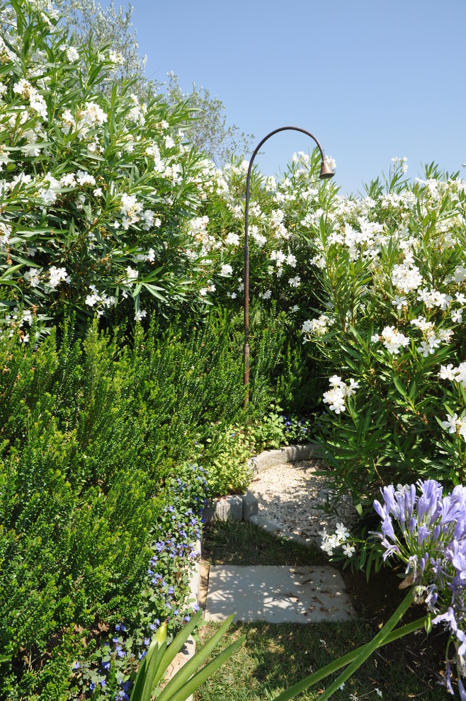 Immagine di un grande giardino formale minimal esposto a mezz'ombra dietro casa in primavera con ghiaia