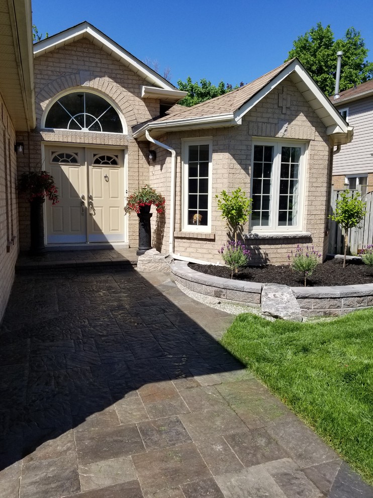 Стильный дизайн: весенний регулярный сад на переднем дворе в классическом стиле с садовой дорожкой или калиткой, полуденной тенью и покрытием из каменной брусчатки - последний тренд