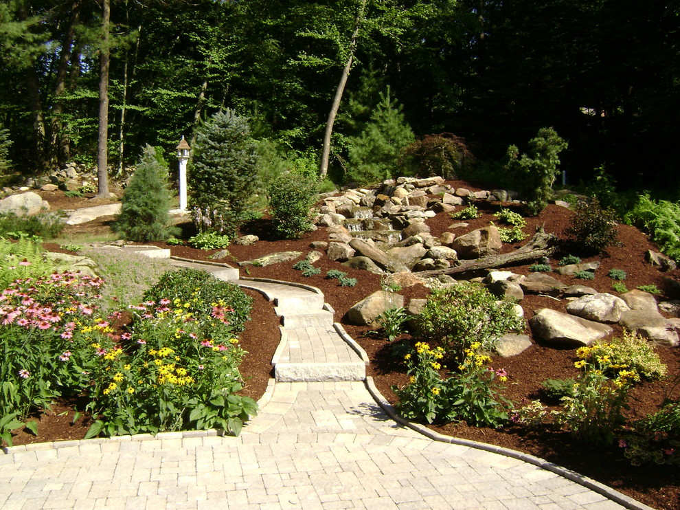 Großer, Geometrischer Uriger Garten hinter dem Haus mit direkter Sonneneinstrahlung, Pflastersteinen und Wasserspiel in New York