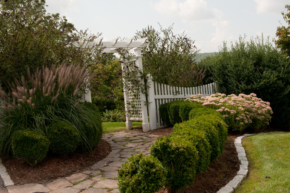 Inspiration pour un aménagement d'entrée ou allée de jardin latéral traditionnel avec des pavés en pierre naturelle.