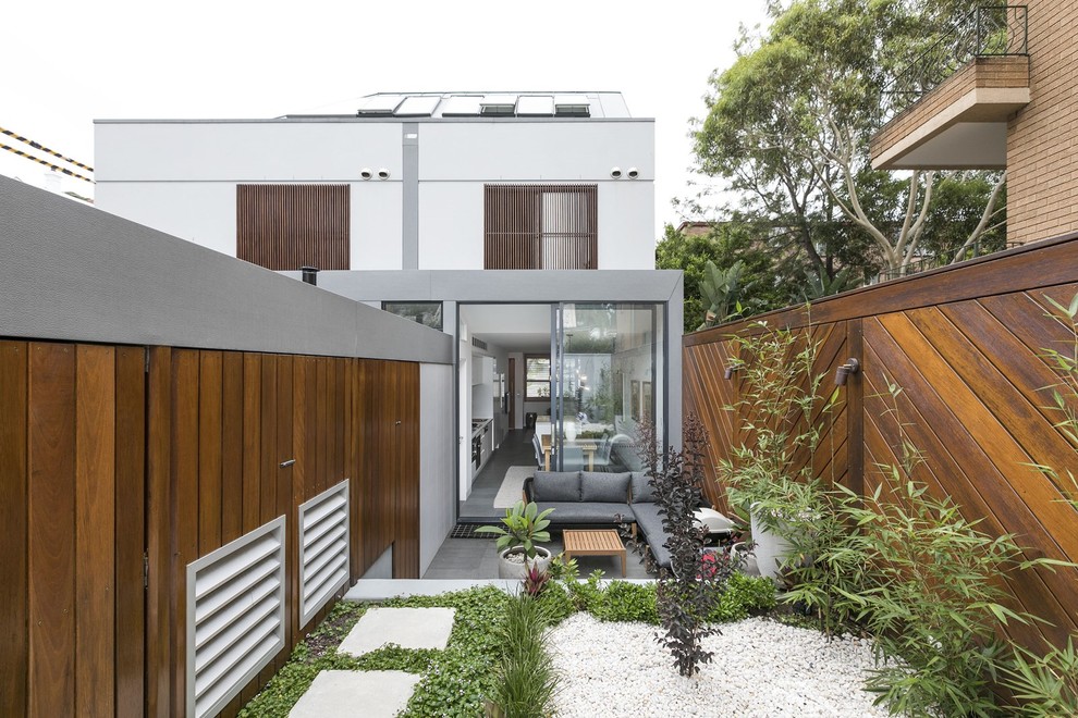 Inspiration för moderna bakgårdar i full sol, med en stödmur och marksten i betong