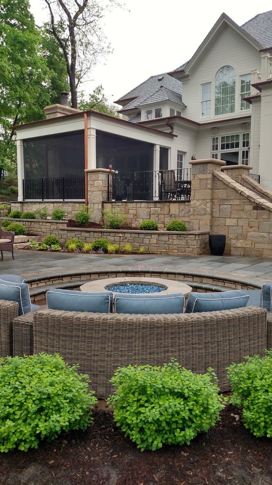Photo of a large contemporary back partial sun garden in Chicago with a fire feature and natural stone paving.