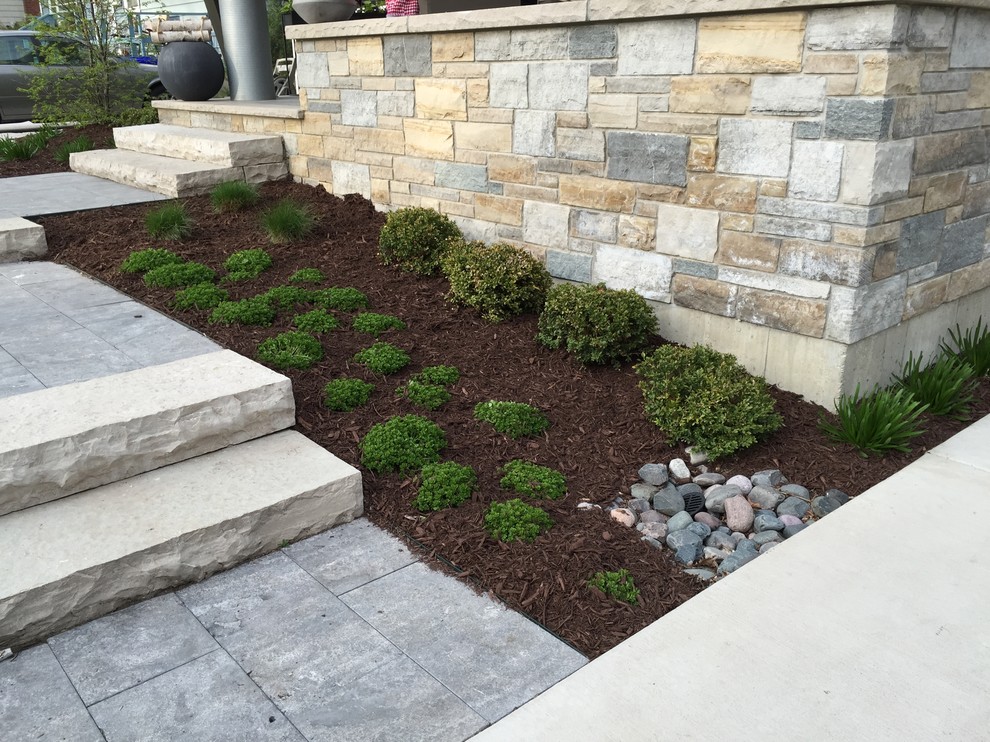 Inspiration for a small modern partial sun and drought-tolerant front yard stone water fountain landscape in Chicago for summer.