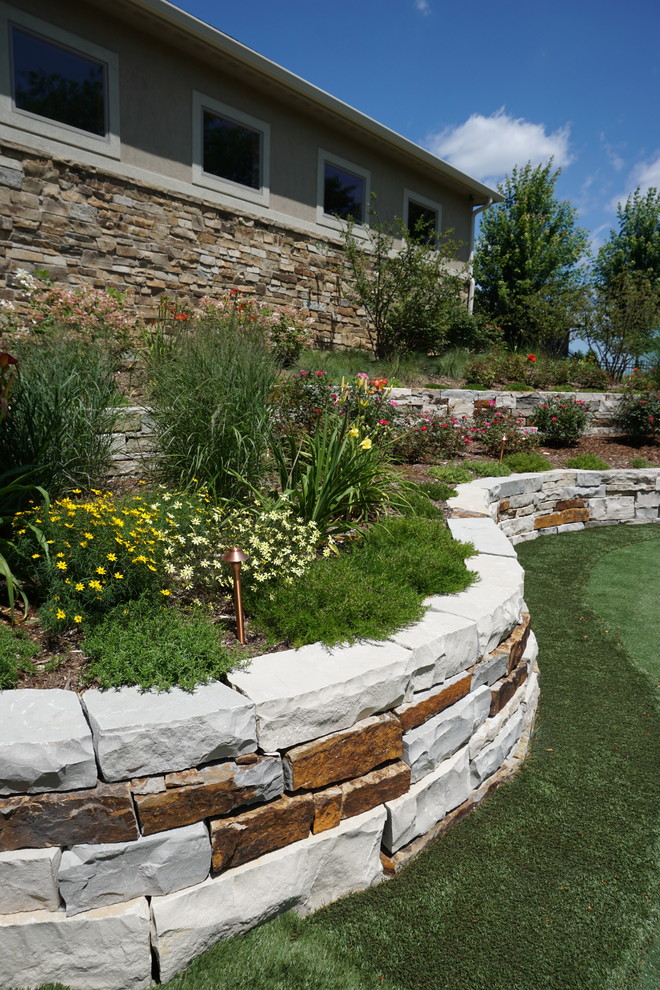 Design ideas for a large classic back full sun garden in Other with a retaining wall and natural stone paving.