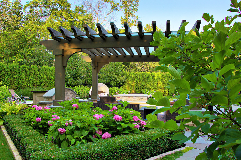 Foto de camino de jardín tradicional de tamaño medio en patio trasero con adoquines de piedra natural, jardín francés y exposición parcial al sol