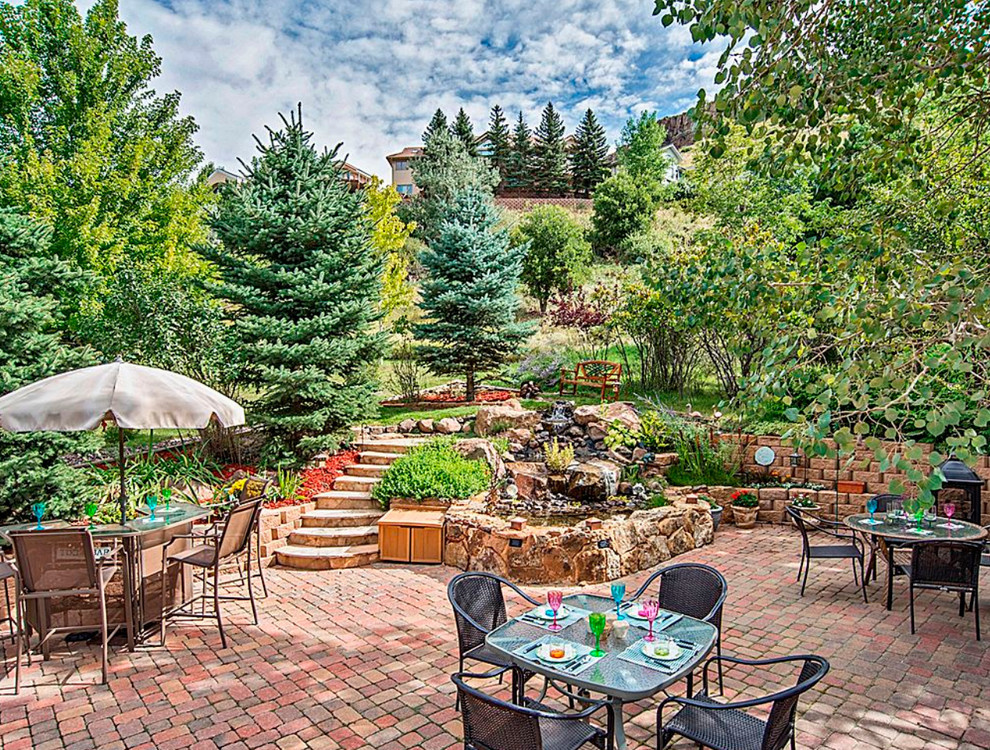Large classic back garden in Denver with brick paving.