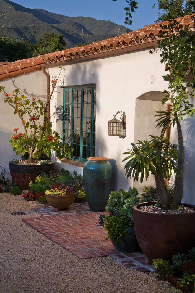 Источник вдохновения для домашнего уюта: большой участок и сад на переднем дворе в средиземноморском стиле с покрытием из гравия