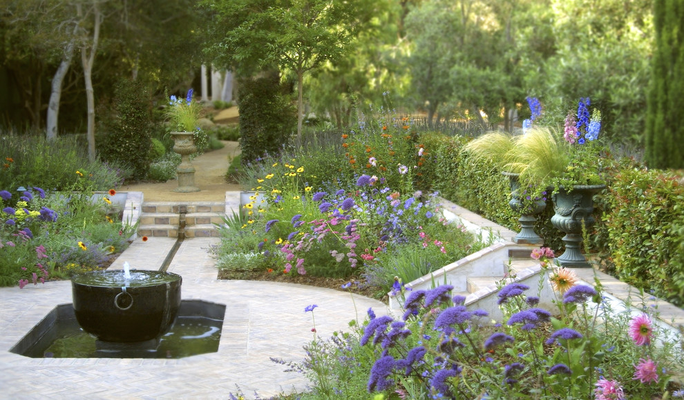 Cette photo montre un jardin à la française arrière chic de taille moyenne avec un point d'eau, une exposition ensoleillée et des pavés en pierre naturelle.