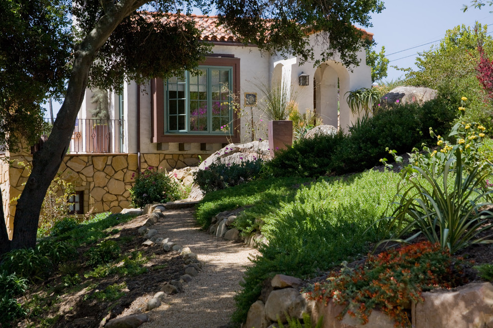 This is an example of a large mediterranean front yard gravel landscaping in Santa Barbara.