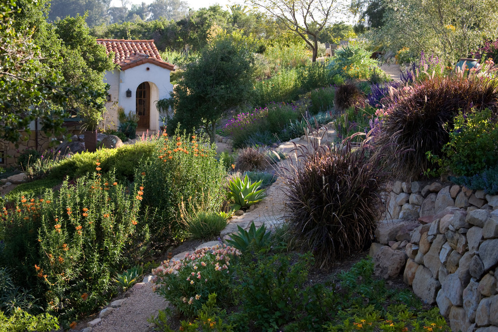 Cette photo montre un grand jardin avant méditerranéen avec un mur de soutènement et du gravier.