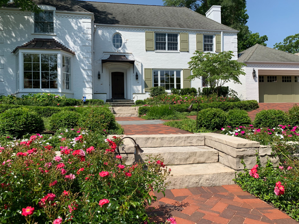 Esempio di un grande giardino formale tradizionale esposto a mezz'ombra davanti casa in estate con pavimentazioni in pietra naturale e un muro di contenimento