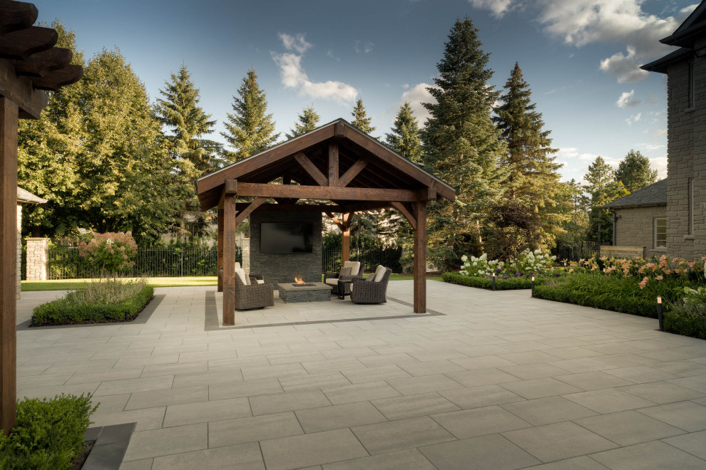 Immagine di un ampio giardino design esposto in pieno sole dietro casa in estate con pavimentazioni in cemento