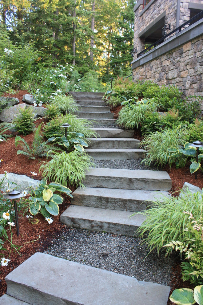 На фото: большой весенний регулярный сад на заднем дворе в современном стиле с полуденной тенью и покрытием из каменной брусчатки