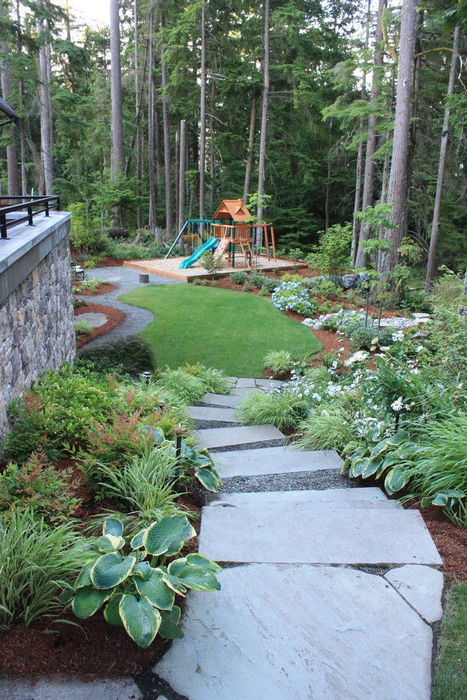 Photo of a large contemporary partial sun backyard stone landscaping in Seattle for spring.