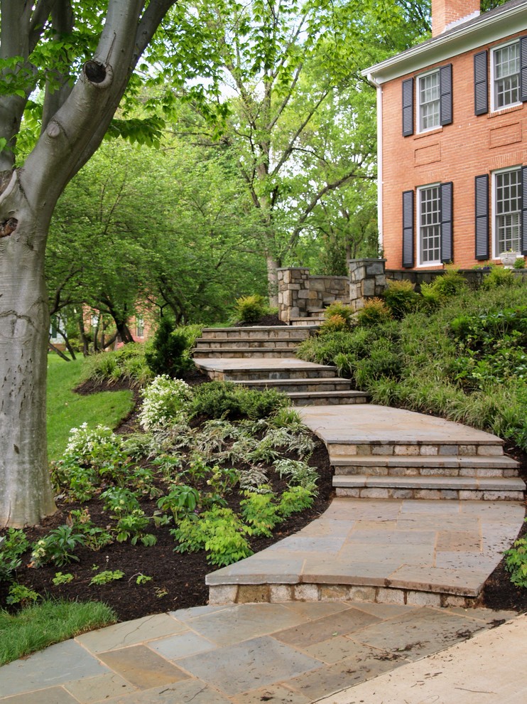 This is an example of a large traditional full sun front yard stone landscaping in DC Metro.