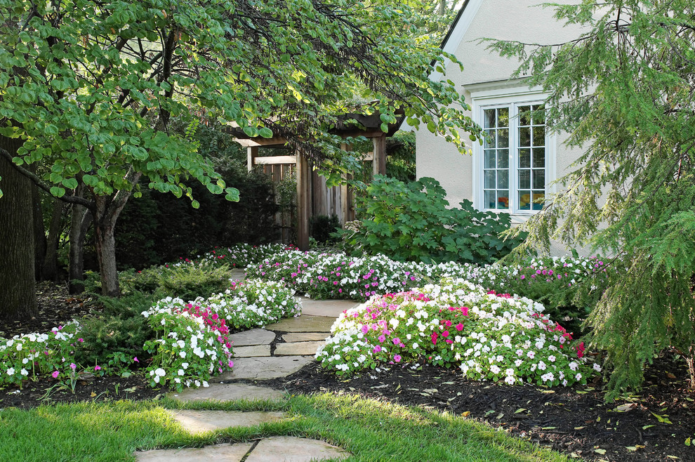 На фото: тенистый регулярный сад среднего размера на заднем дворе в классическом стиле с покрытием из каменной брусчатки с