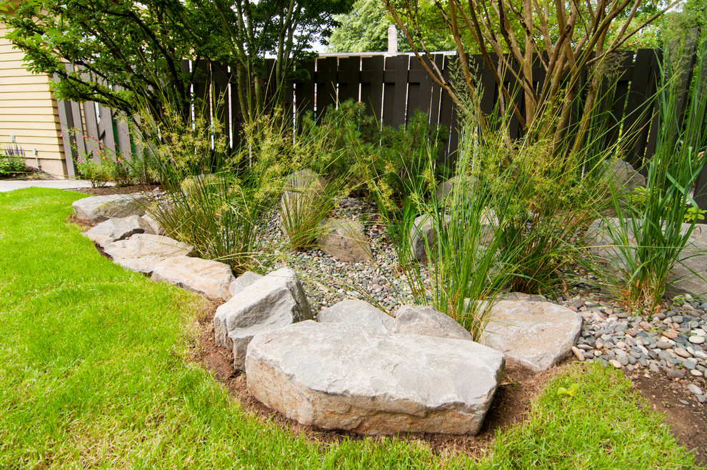 Small rustic back xeriscape full sun garden for winter in Portland with a water feature.