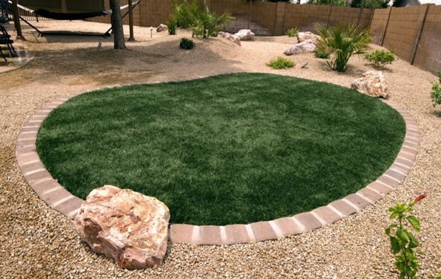 This is an example of a mid-sized southwestern full sun backyard brick pond in Phoenix for summer.