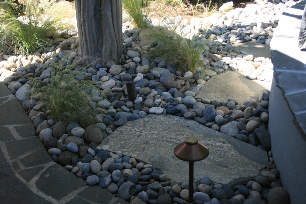 This is an example of a mid-sized traditional partial sun backyard stone landscaping in San Francisco for spring.