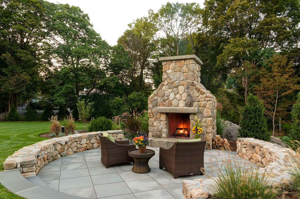Foto di un patio o portico tradizionale dietro casa con un focolare e pavimentazioni in pietra naturale