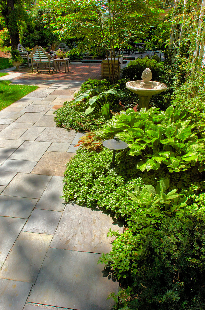 Immagine di un grande giardino formale tradizionale esposto a mezz'ombra dietro casa in estate con un ingresso o sentiero e pavimentazioni in pietra naturale