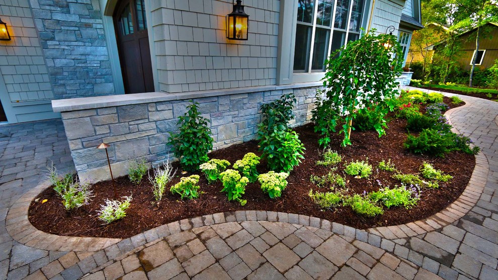 Photo of a mid-sized traditional shade front yard stone driveway in Minneapolis.